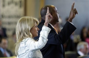 Sen. Wendy Davis, D-Fort Worth, left, and Sen. Rodney Ellis, D-Houston, right, vote against a motion to call for a rules violation during Davis' filibusters of an abortion bill, Tuesday, June 25, 2013, in Austin, Texas. Davis was given a second warning for breaking filibuster rules by receiving help from Ellis with a back brace. (AP Photo/Eric Gay)