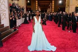 Lupita Nyong'o on the red carpet at the Oscars in "Nairobi Blue" Prada gown.