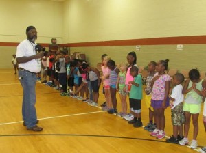 Friends of Emancipation volunteer Rev. Dr. Robert Gilmore and children saying a blessing before the birthday meal.