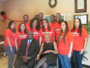 Dr. Bernadette Iguh, black dress, seated next to her husband and with staff.