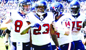 Houston Texans running back Arian Foster (23) celebrates after a 40-yard rush and is greeted by teammates photo credit AP/Ben Maggot.