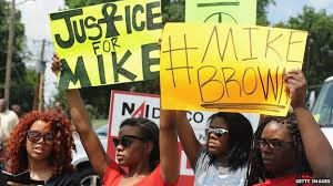 Ferguson protestors hold up signs for justice for Michael Brown.